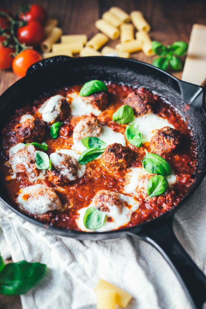 Rezept für den amerikanisch-italienischen Klassiker Baked Meatballs. Das sind saftige gratinierte Hackbällchen in Tomatensauce, die mit Mozzarella überbacken werden. Hier kennt man sie auch als "Hackbällchen Toskana". Sie schmecken fantastisch zu Pasta wie Spaghetti, Rigatoni oder auch einfach mit frischem, knusprigem Brot. | moeyskitchen.com