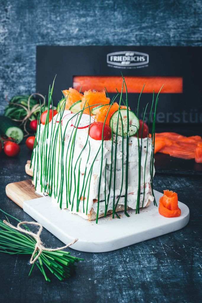 Perfekt für den Oster-Brunch oder das Sonntagsfrühstück: Herzhafte Sandwich-Torte mit geräucherter Fjordforelle, Gurke, Radieschen und Frischkäse-Creme. Aus frischem Kastenweißbrot so lecker und bunt verziert ein echter Hingucker! Diese Torte ist super einfach hergestellt und besteht aus wenigen guten Zutaten. Meine herzhafte Sandwich-Torte erinnert an die schwedische Smörgåstårta, die man traditionell zu Midsommar serviert. Sie passt aber auch einfach hervorragend in den Frühling und sieht auch als Mitbringsel großartig aus! | moeyskitchen.com