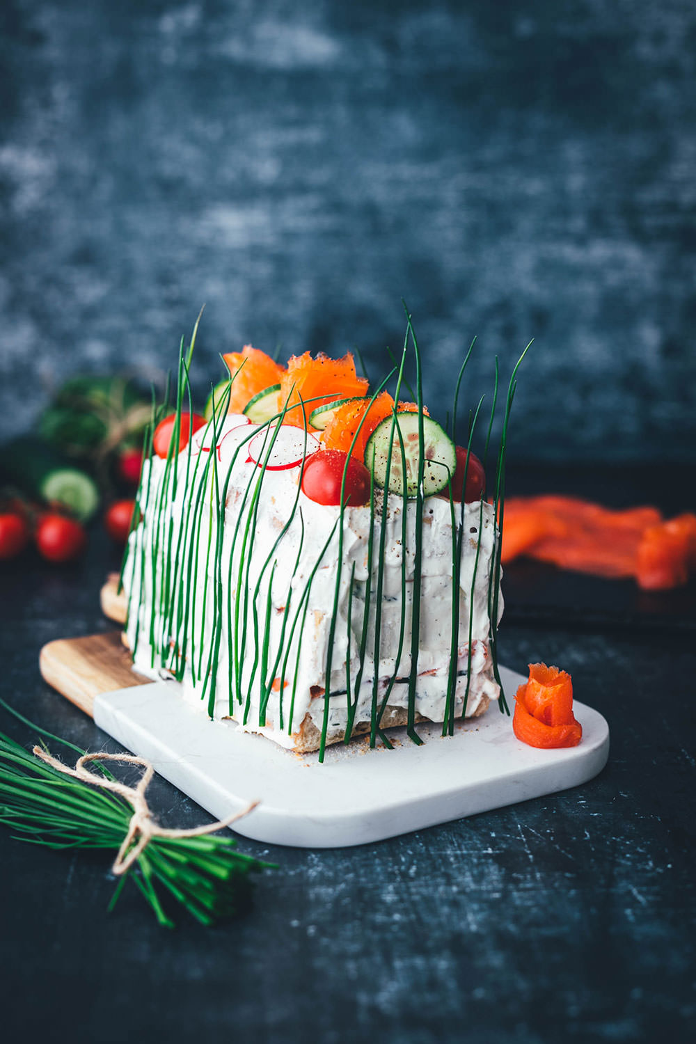 Perfekt für den Oster-Brunch oder das Sonntagsfrühstück: Herzhafte Sandwich-Torte mit geräucherter Fjordforelle, Gurke, Radieschen und Frischkäse-Creme. Aus frischem Kastenweißbrot so lecker und bunt verziert ein echter Hingucker! Diese Torte ist super einfach hergestellt und besteht aus wenigen guten Zutaten. Meine herzhafte Sandwich-Torte erinnert an die schwedische Smörgåstårta, die man traditionell zu Midsommar serviert. Sie passt aber auch einfach hervorragend in den Frühling und sieht auch als Mitbringsel großartig aus! | moeyskitchen.com