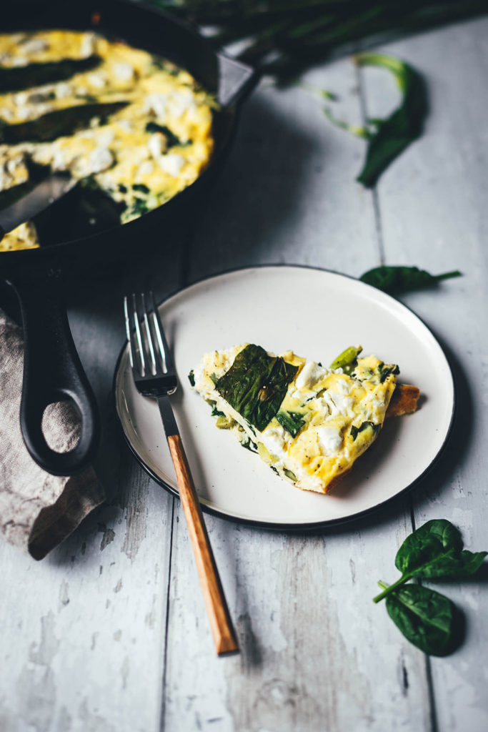 Rezept für locker-leichte Bärlauch-Frittata. Saftiges Omelette, das erst in der Pfanne vorbereitet und anschließend im Ofen gegart wird. Leckere Frühlingsküche mit Bärlauch, Babyspinat, grünem Spargel und Feta. | moeyskitchen.com