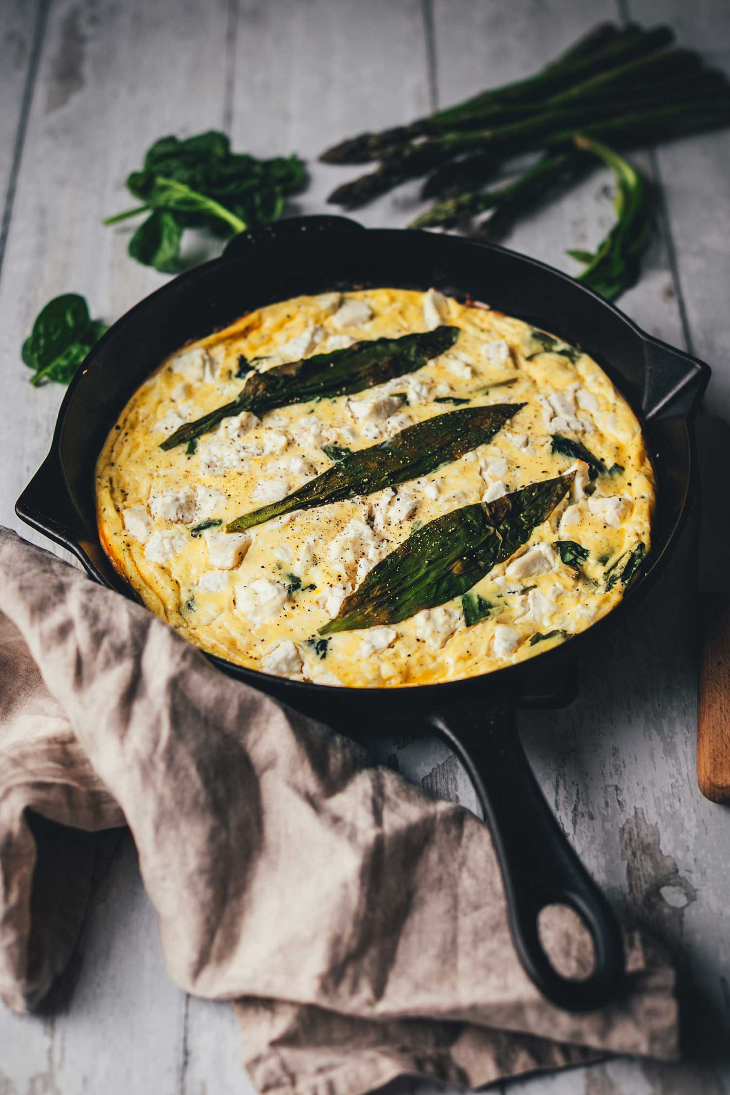 Seitliche Ansicht der fertig gegarten Bärlauch-Frittata in einer gusseisernen Pfanne. Bereit zum Servieren.