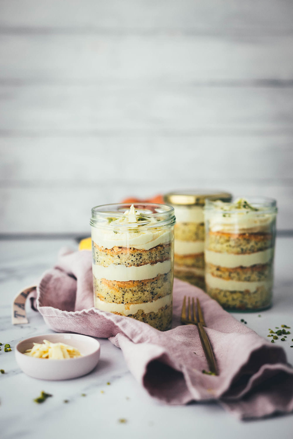 Entzückende Zitronen-Mohn-Törtchen mit weißer Schokoladen-Ganache – als kleine Torte im Einmachglas geschichtet und damit perfekt zum Mitnehmen und Verschenken! Saftiger Rührkuchen wird auf dem Blech gebacken, ausgestochen und abwechselnd mit einer leckeren Schoko-Ganache ins Glas drapiert. Gut verschlossen halten die kleinen Törtchen ein paar Tage im Kühlschrank. Auch perfekt für das Picknick draußen oder einen Spaziergang, zum Beispiel als Geburtstagstorte für eine Person oder einen anderen schönen Anlass. Es gibt immer einen Grund zu feiern! | moeyskitchen.com