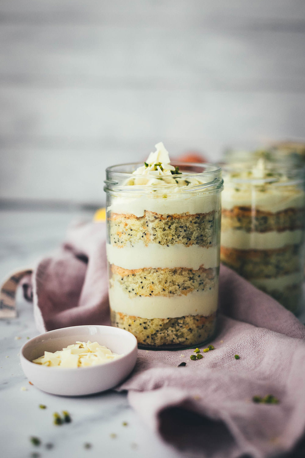 Entzückende Zitronen-Mohn-Törtchen mit weißer Schokoladen-Ganache – als kleine Torte im Einmachglas geschichtet und damit perfekt zum Mitnehmen und Verschenken! Saftiger Rührkuchen wird auf dem Blech gebacken, ausgestochen und abwechselnd mit einer leckeren Schoko-Ganache ins Glas drapiert. Gut verschlossen halten die kleinen Törtchen ein paar Tage im Kühlschrank. Auch perfekt für das Picknick draußen oder einen Spaziergang, zum Beispiel als Geburtstagstorte für eine Person oder einen anderen schönen Anlass. Es gibt immer einen Grund zu feiern! | moeyskitchen.com