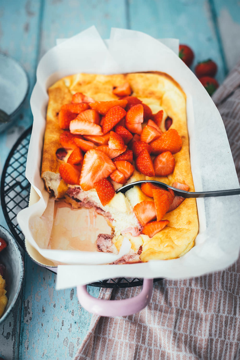 Rezept für luftigen Quark-Auflauf mit Erdbeeren. Leckeres, nicht zu süßes Dessert oder Frühstück für die ganze Familie! Magerquark wird dazu einfach mit Ei und Grieß locker aufgeschlagen und dann mit Erdbeeren in einer Auflaufform gebacken. Anschließend lauwarm mit frischen Erdbeeren serviert, so dass es an einen leckeren, aber unheimlich einfachen Käsekuchen erinnert. | moeyskitchen.com