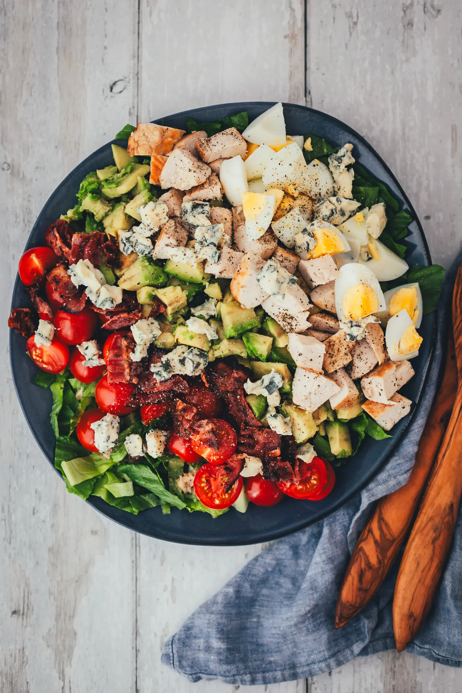 Cobb Salad aus der Vogelperspektive, die einzelnen Zutaten in farbigen Reihen auf dem Teller angerichtet.