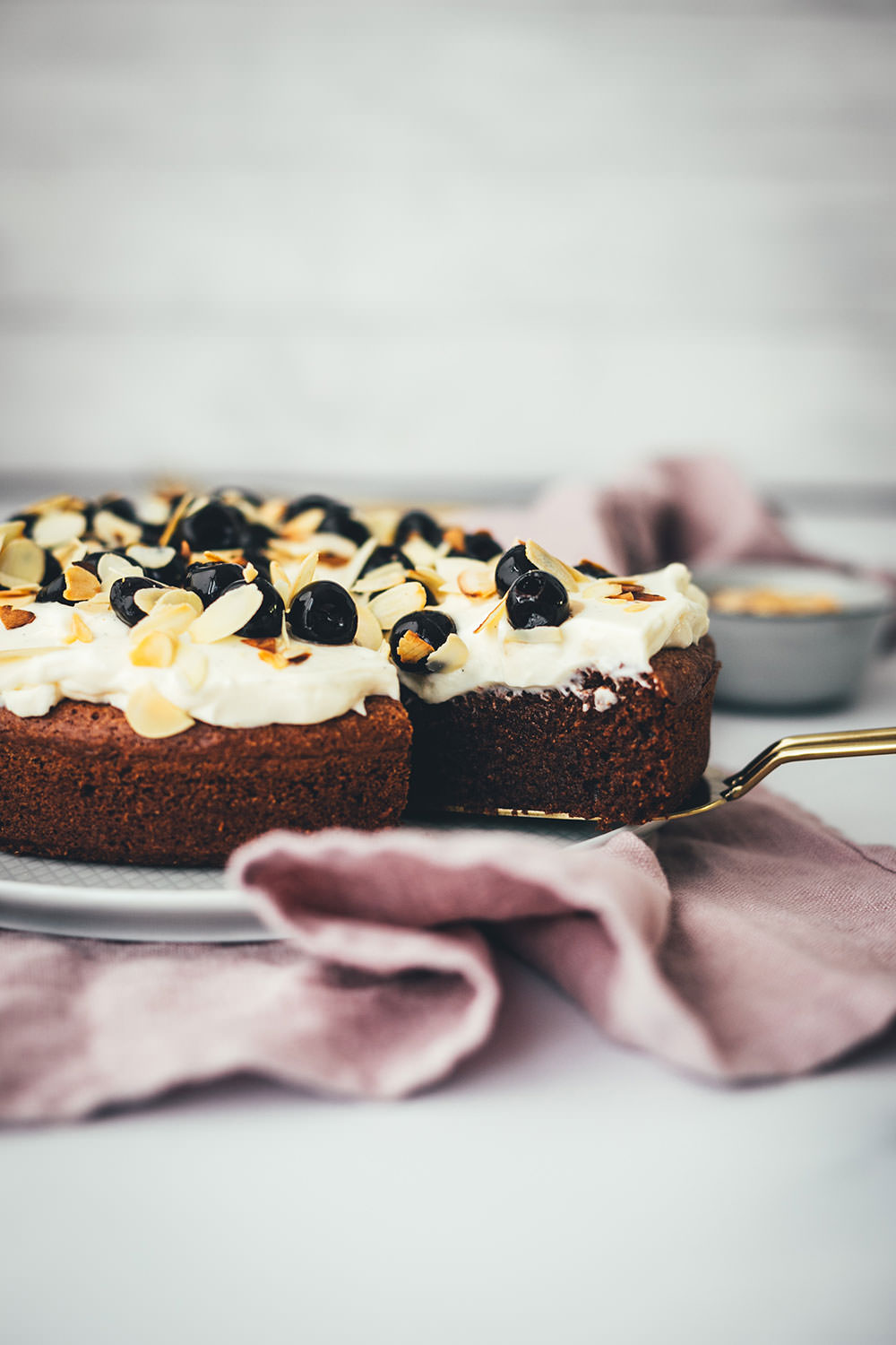 Der italienische Kuchenklassiker in neuem Gewand: Torta Caprese ist ein super saftiger Schokoladenkuchen, der ganz ohne Mehl auskommt. Stattdessen kommen hier zerkleinerte, geröstete Mandeln in den Teig. Und statt die Torta Caprese wie im Original nur mit Puderzucker zu bestreuen, serviere ich sie hier mit einer wunderbaren Mascarpone-Creme, leckeren Amarenakirschen und zusätzlich mit gerösteten Mandelblättchen. Der saftigste Schokokuchen überhaupt! | moeyskitchen.com