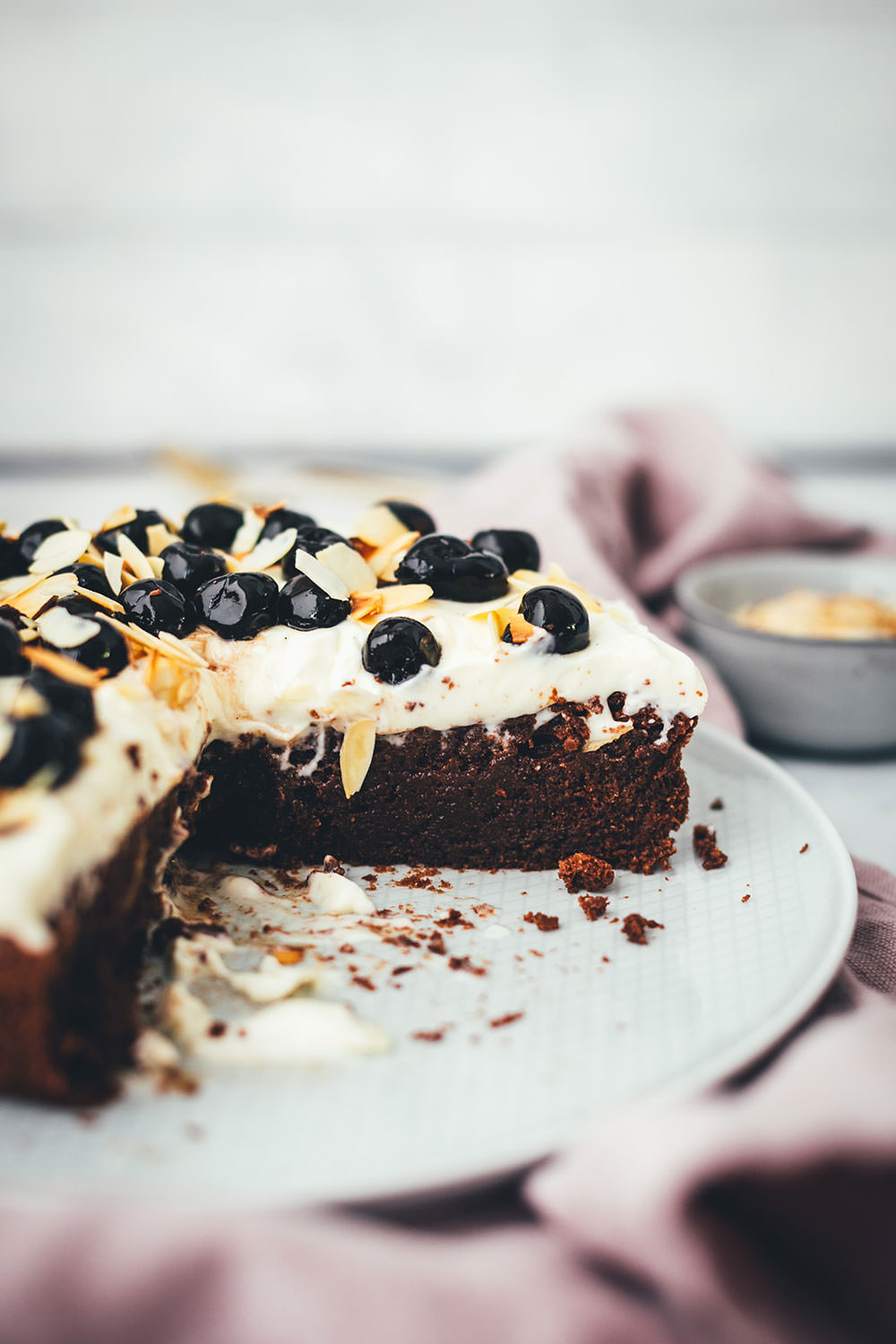 Der italienische Kuchenklassiker in neuem Gewand: Torta Caprese ist ein super saftiger Schokoladenkuchen, der ganz ohne Mehl auskommt. Stattdessen kommen hier zerkleinerte, geröstete Mandeln in den Teig. Und statt die Torta Caprese wie im Original nur mit Puderzucker zu bestreuen, serviere ich sie hier mit einer wunderbaren Mascarpone-Creme, leckeren Amarenakirschen und zusätzlich mit gerösteten Mandelblättchen. Der saftigste Schokokuchen überhaupt! | moeyskitchen.com