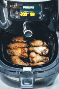 Rezept für die besten Chicken Wings aus dem Airfryer – die Hähnchenflügel werden in der Heißluftfritteuse super zart und saftig. Hier serviere ich sie mit einem einfachen, asiatisch gewürzten Krautsalat als Coleslaw mit Spitzkohl und Möhren | moeyskitchen.com