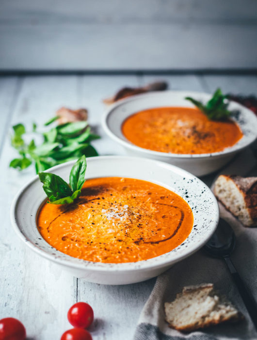 Rezept für cremige Tomatensuppe als blitzschnelle Rösttomatensuppe aus dem Ofen. Verfeinert mit Zwiebeln, Knoblauch, Parmesan und Basilikum. Fix auf dem Tisch und perfekt für die schnelle Feierabendküche im Spätsommer! | moeyskitchen.com