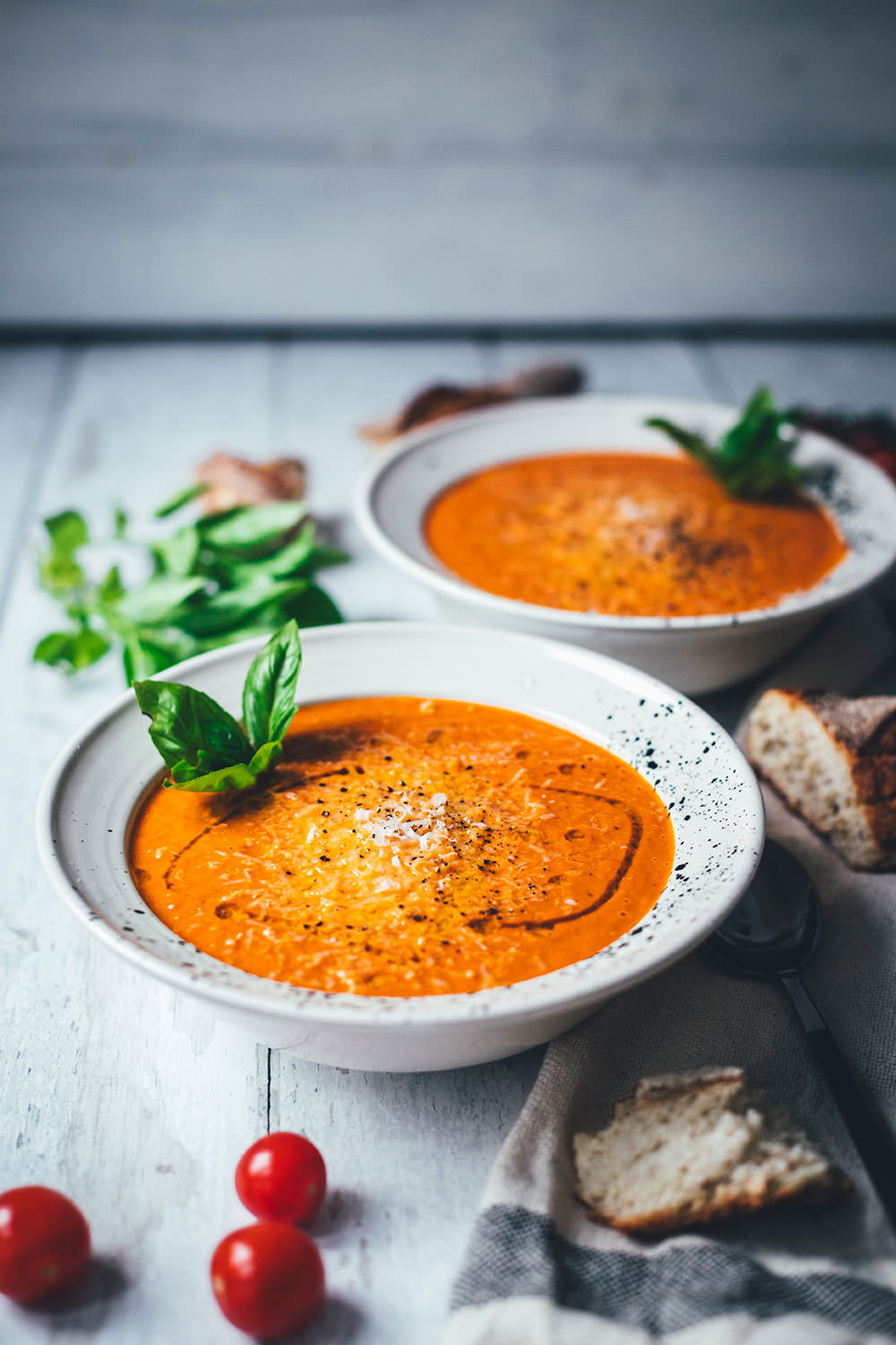 Rezept für cremige Tomatensuppe als blitzschnelle Rösttomatensuppe aus dem Ofen. Verfeinert mit Zwiebeln, Knoblauch, Parmesan und Basilikum. Fix auf dem Tisch und perfekt für die schnelle Feierabendküche im Spätsommer! | moeyskitchen.com