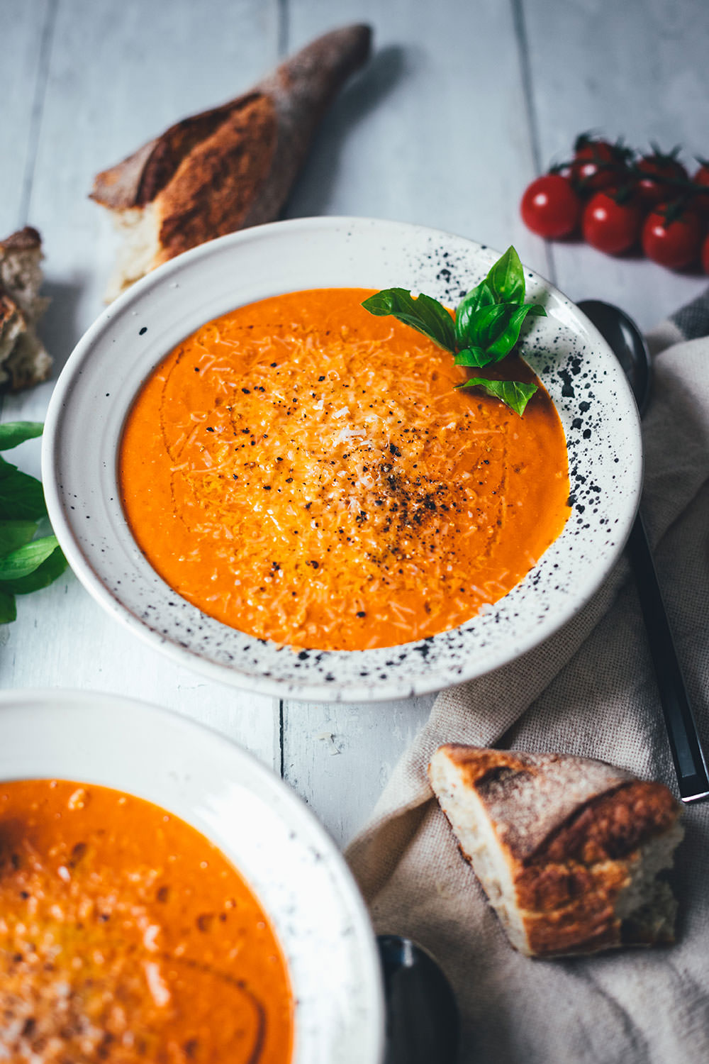 Rezept für cremige Tomatensuppe als blitzschnelle Rösttomatensuppe aus dem Ofen. Verfeinert mit Zwiebeln, Knoblauch, Parmesan und Basilikum. Fix auf dem Tisch und perfekt für die schnelle Feierabendküche im Spätsommer! | moeyskitchen.com