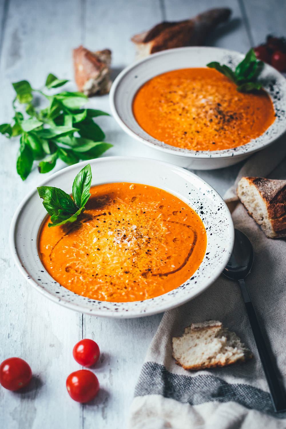 Rezept für cremige Tomatensuppe als blitzschnelle Rösttomatensuppe aus dem Ofen. Verfeinert mit Zwiebeln, Knoblauch, Parmesan und Basilikum. Fix auf dem Tisch und perfekt für die schnelle Feierabendküche im Spätsommer! | moeyskitchen.com