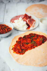 Rezept für knusprige Calzone – italienische Pizza, die als Pizzatasche gebacken wird. Mit leckerer Füllung aus Tomatensauce, Mozzarella, Schinken und Salami. Lässt sich super vorbereiten, einfrieren und frisch genießen. Ganz easy zu Hause selber machen und im normalen Ofen backen! | moeyskitchen.com