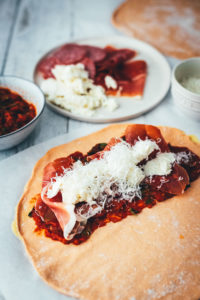 Rezept für knusprige Calzone – italienische Pizza, die als Pizzatasche gebacken wird. Mit leckerer Füllung aus Tomatensauce, Mozzarella, Schinken und Salami. Lässt sich super vorbereiten, einfrieren und frisch genießen. Ganz easy zu Hause selber machen und im normalen Ofen backen! | moeyskitchen.com
