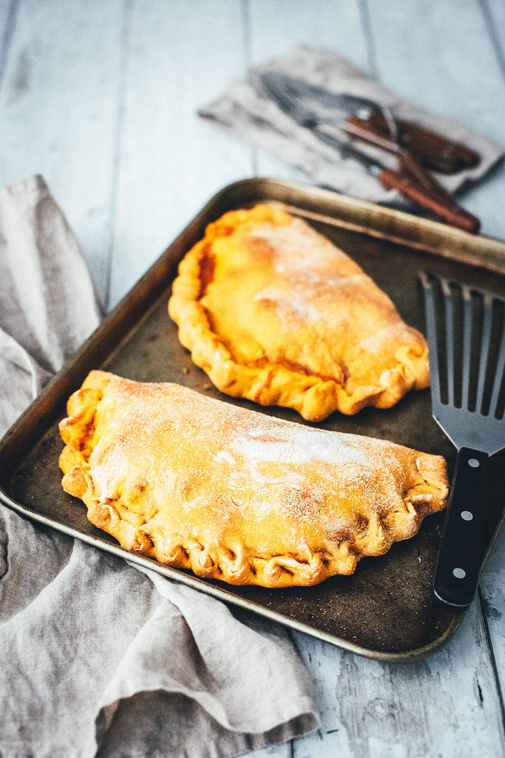 Rezept für knusprige Calzone – italienische Pizza, die als Pizzatasche gebacken wird. Mit leckerer Füllung aus Tomatensauce, Mozzarella, Schinken und Salami. Lässt sich super vorbereiten, einfrieren und frisch genießen. Ganz easy zu Hause selber machen und im normalen Ofen backen! | moeyskitchen.com