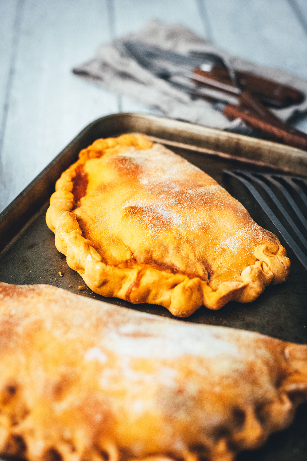 Rezept für knusprige Calzone – italienische Pizza, die als Pizzatasche gebacken wird. Mit leckerer Füllung aus Tomatensauce, Mozzarella, Schinken und Salami. Lässt sich super vorbereiten, einfrieren und frisch genießen. Ganz easy zu Hause selber machen und im normalen Ofen backen! | moeyskitchen.com