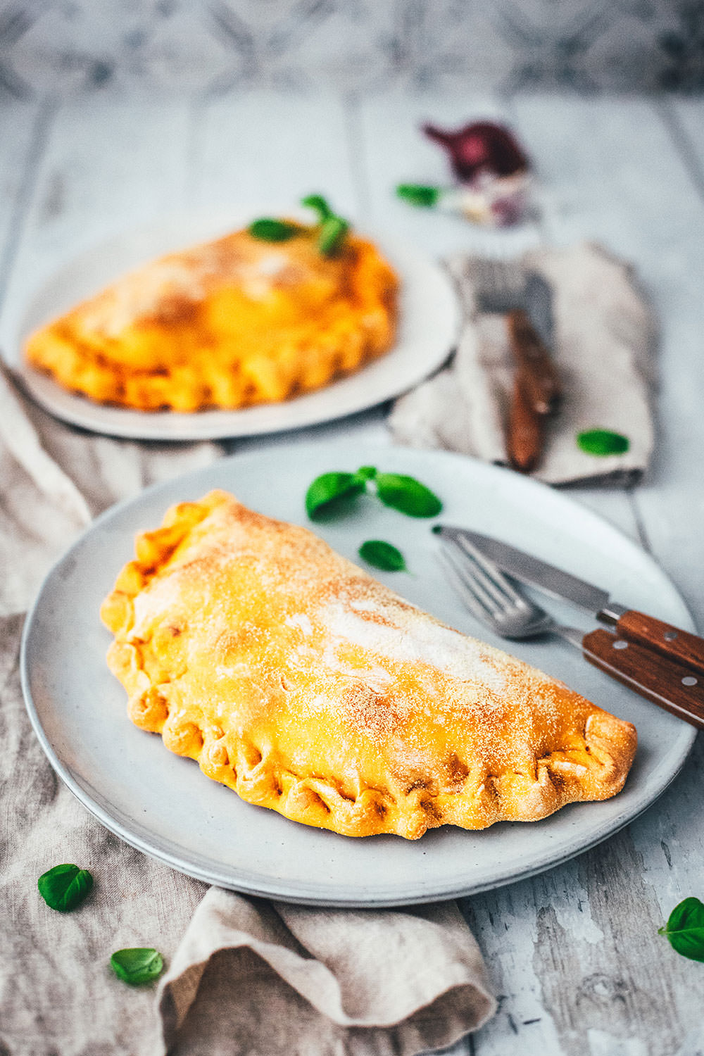 Rezept für knusprige Calzone – italienische Pizza, die als Pizzatasche gebacken wird. Mit leckerer Füllung aus Tomatensauce, Mozzarella, Schinken und Salami. Lässt sich super vorbereiten, einfrieren und frisch genießen. Ganz easy zu Hause selber machen und im normalen Ofen backen! | moeyskitchen.com