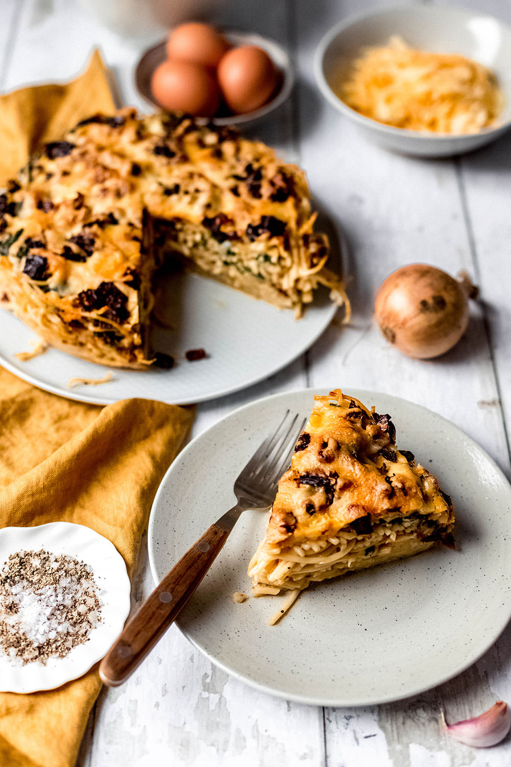 Rezept für herzhaften Spaghetti-Kuchen. Vegetarischer Nudelauflauf mit frischem Spinat und getrockneten Tomaten. Gebacken in einer Spingform und serviert in Form von Kuchenstücken | moeyskitchen.com