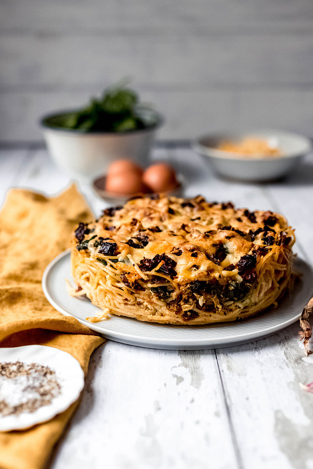 Rezept für herzhaften Spaghetti-Kuchen. Vegetarischer Nudelauflauf mit frischem Spinat und getrockneten Tomaten. Gebacken in einer Spingform und serviert in Form von Kuchenstücken | moeyskitchen.com