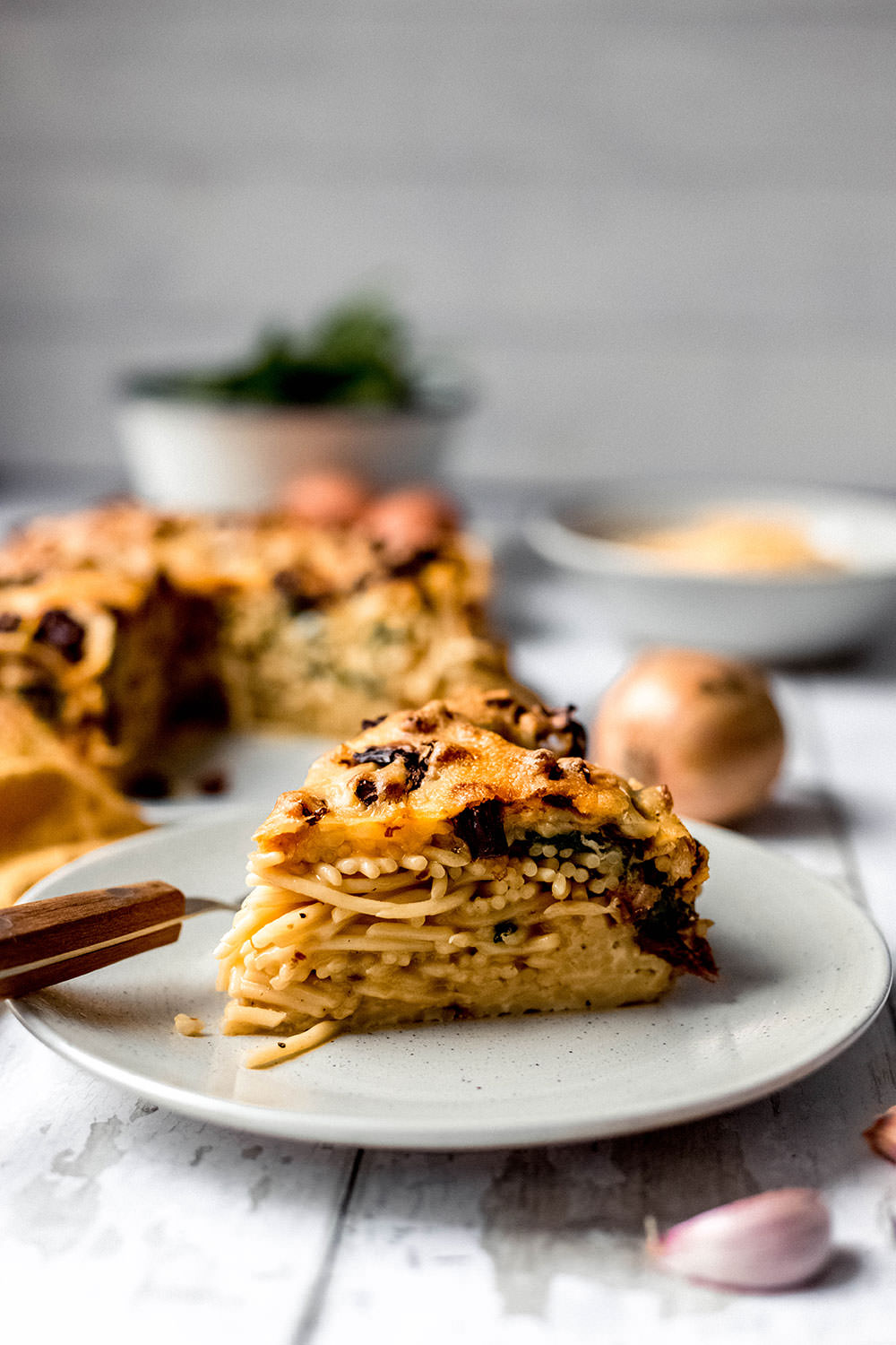 Rezept für herzhaften Spaghetti-Kuchen. Vegetarischer Nudelauflauf mit frischem Spinat und getrockneten Tomaten. Gebacken in einer Spingform und serviert in Form von Kuchenstücken | moeyskitchen.com