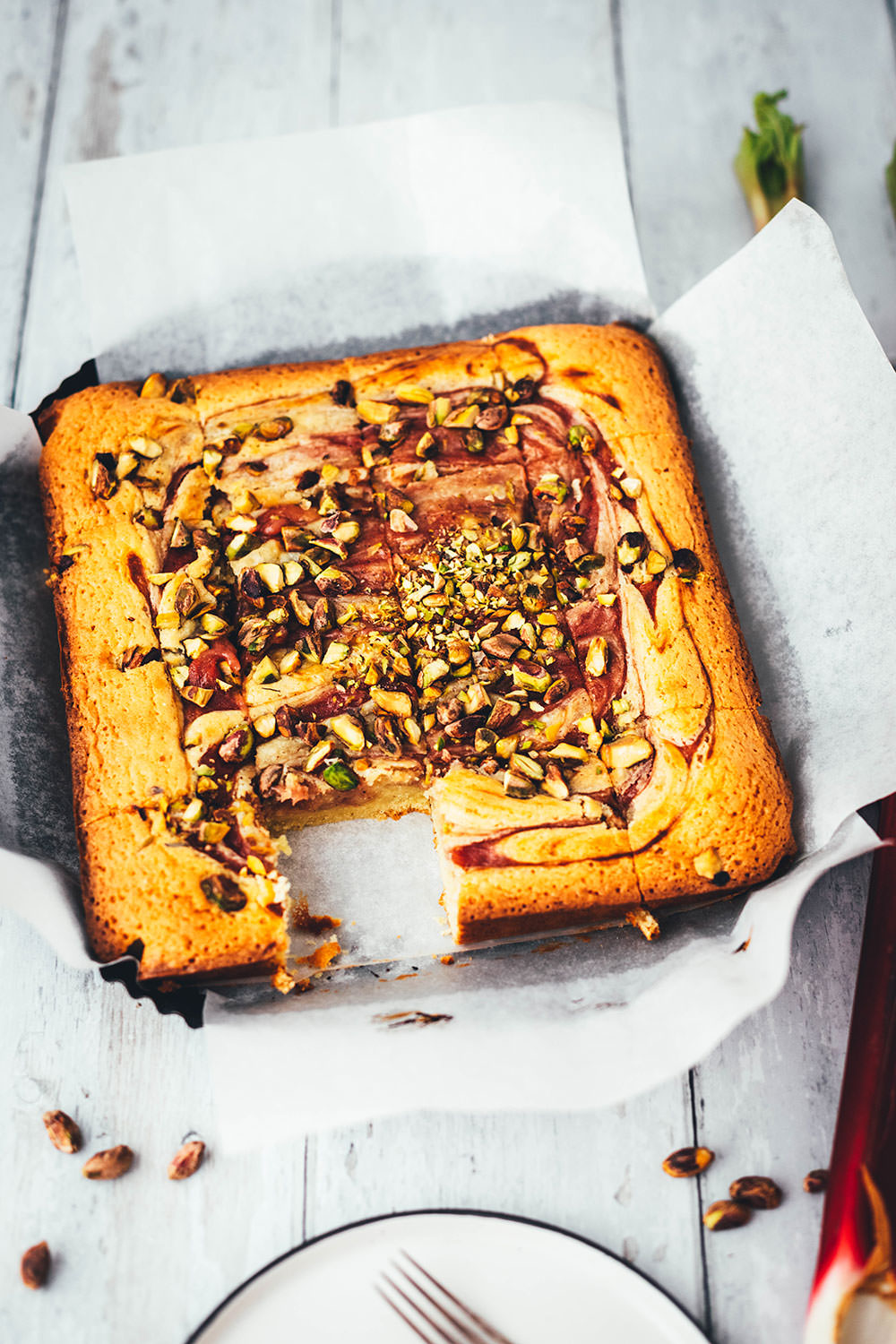 Jetzt ist die perfekte Zeit für leckeren Rhabarber-Kuchen gekommen. Hier gibt es heute deswegen eine neue Rezeptidee von mir: saftige Rhabarber-Blondies, die mit weißer Schokolade und knackigen Pistazien gebacken werden. Der Rhabarber wandert püriert und ohne Stückchen in die Blondies. So sorgt er nicht nur für einen hübschen Swirl, sondern schmeckt auch den Menschen, die sonst nicht die größten Rhabarber-Fans sind. | moeyskitchen.com