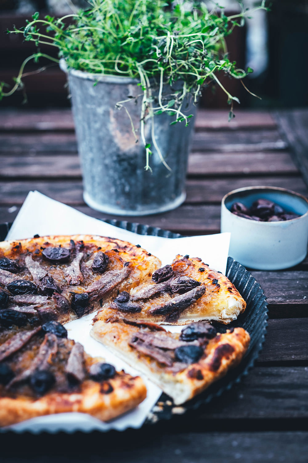 Rezept für einfache Pissaladière - herzhafter Zwiebelkuchen aus Blätterteig. Die französische Tarte wird deftig und würzig mit Sardellen (Anchovis) und schwarzen Oliven belegt. Köstlich zu einem Glas Rosé! | moeyskitchen.com
