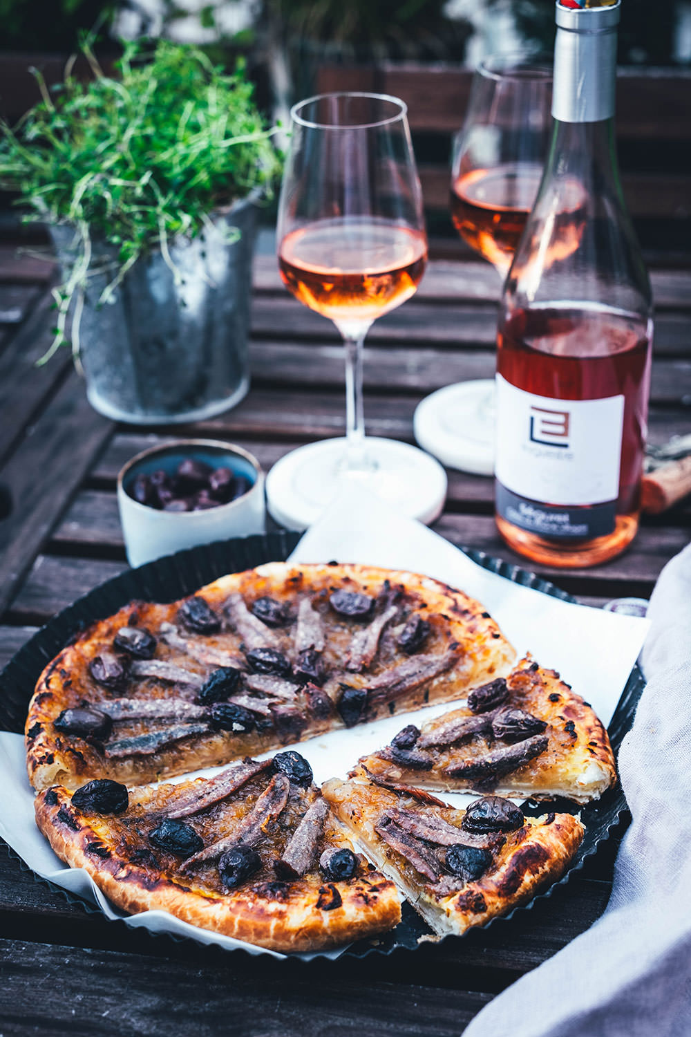 Rezept für einfache Pissaladière - herzhafter Zwiebelkuchen aus Blätterteig. Die französische Tarte wird deftig und würzig mit Sardellen (Anchovis) und schwarzen Oliven belegt. Köstlich zu einem Glas Rosé! | moeyskitchen.com