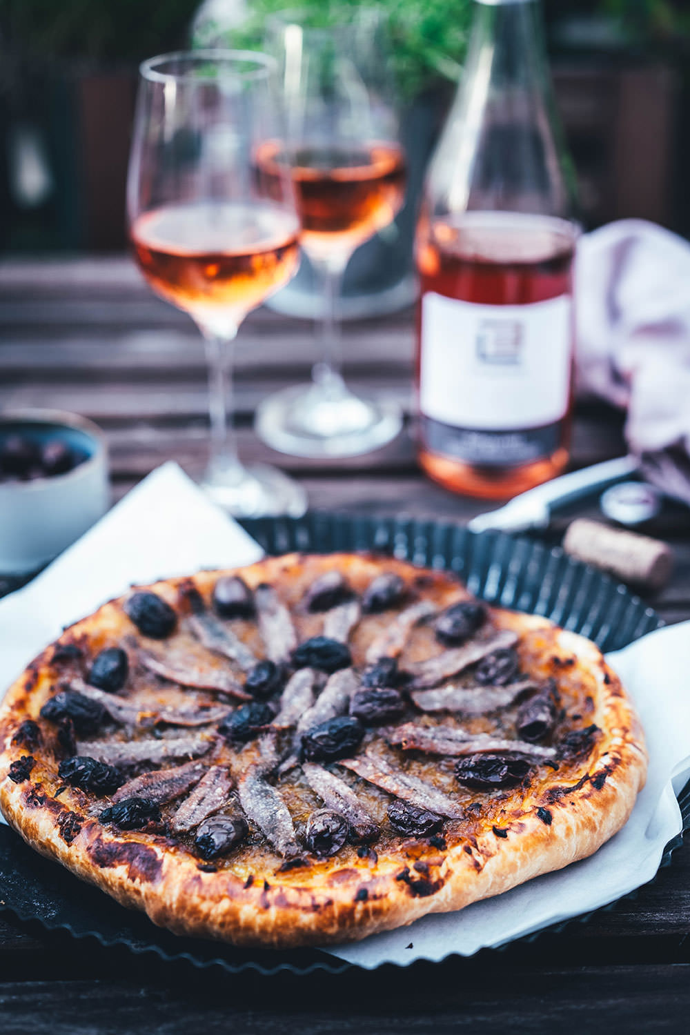 Rezept für einfache Pissaladière - herzhafter Zwiebelkuchen aus Blätterteig. Die französische Tarte wird deftig und würzig mit Sardellen (Anchovis) und schwarzen Oliven belegt. Köstlich zu einem Glas Rosé! | moeyskitchen.com