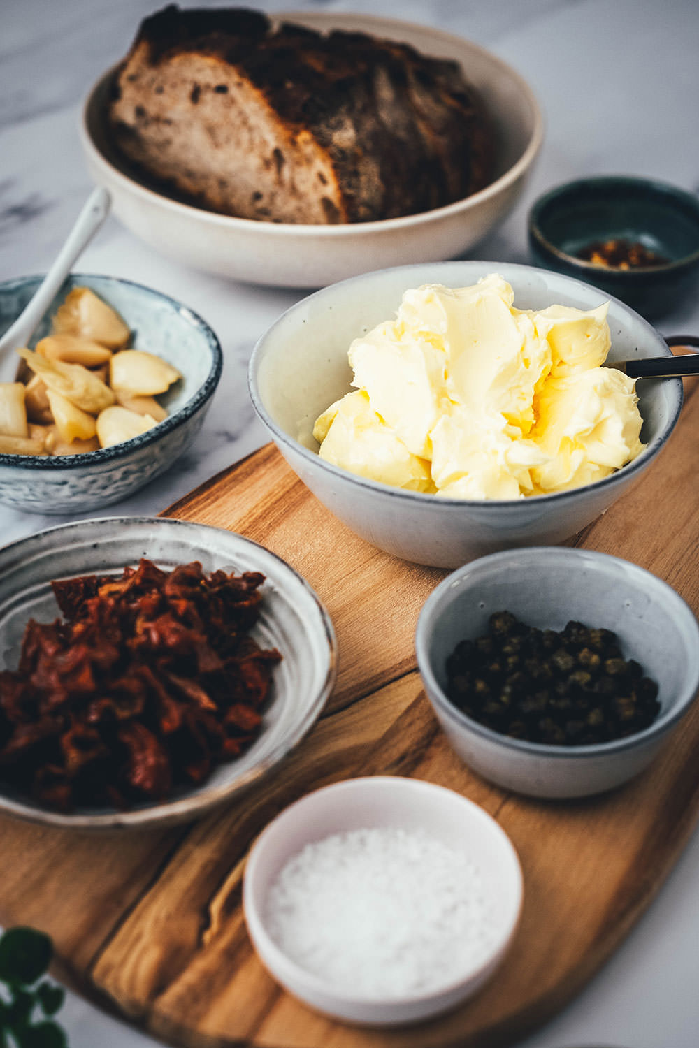 Rezept für ein Butter Board. Das Trend-Gericht von TikTok jetzt in meiner Version! Hier als herzhafte Variante mit geröstetem Knoblauch, getrockneten Tomaten und frittierten Kapern. Alle Infos zu Butter Boards und ob sie den Hype wert sind, hier im Blog! | moeyskitchen.com