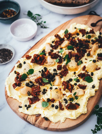 Rezept für ein Butter Board. Das Trend-Gericht von TikTok jetzt in meiner Version! Hier als herzhafte Variante mit geröstetem Knoblauch, getrockneten Tomaten und frittierten Kapern. Alle Infos zu Butter Boards und ob sie den Hype wert sind, hier im Blog! | moeyskitchen.com