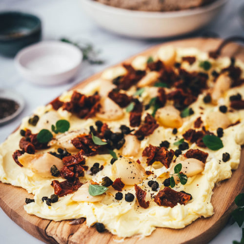 Rezept für ein Butter Board. Das Trend-Gericht von TikTok jetzt in meiner Version! Hier als herzhafte Variante mit geröstetem Knoblauch, getrockneten Tomaten und frittierten Kapern. Alle Infos zu Butter Boards und ob sie den Hype wert sind, hier im Blog! | moeyskitchen.com