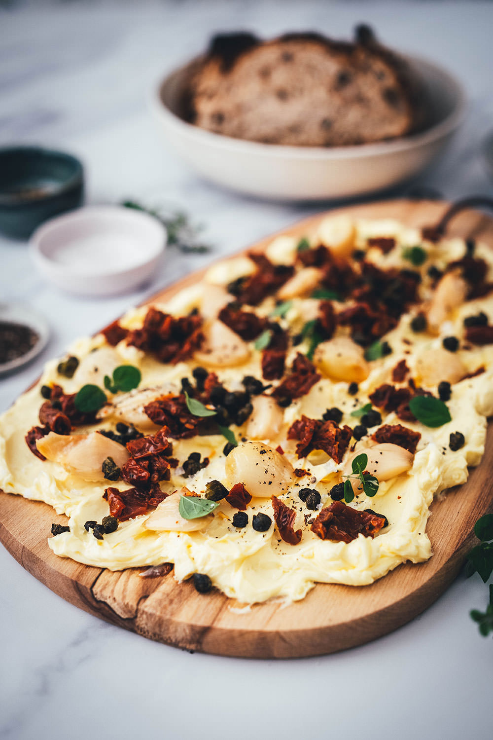 Rezept für ein Butter Board. Das Trend-Gericht von TikTok jetzt in meiner Version! Hier als herzhafte Variante mit geröstetem Knoblauch, getrockneten Tomaten und frittierten Kapern. Alle Infos zu Butter Boards und ob sie den Hype wert sind, hier im Blog! | moeyskitchen.com