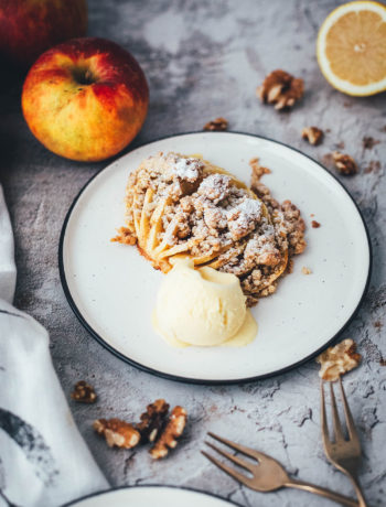 Wunderbare Rezeptidee für gebackene Äpfel mit Streuseln. Süßer Bratapfel trifft auf klassischen Apple Crumble oder Apple Crisp – heraus kommt mein Hasselback Bratapfel. Dafür werden halbierte Äpfel fächerförmig eingeschnitten, im Ofen gebacken und dann mit leckeren Streuseln bestreut. In diesen stecken gehackte Walnüsse und Haferflocken, das macht sie lecker und knusprig! | moeyskitchen.com