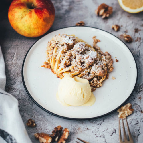 Wunderbare Rezeptidee für gebackene Äpfel mit Streuseln. Süßer Bratapfel trifft auf klassischen Apple Crumble oder Apple Crisp – heraus kommt mein Hasselback Bratapfel. Dafür werden halbierte Äpfel fächerförmig eingeschnitten, im Ofen gebacken und dann mit leckeren Streuseln bestreut. In diesen stecken gehackte Walnüsse und Haferflocken, das macht sie lecker und knusprig! | moeyskitchen.com