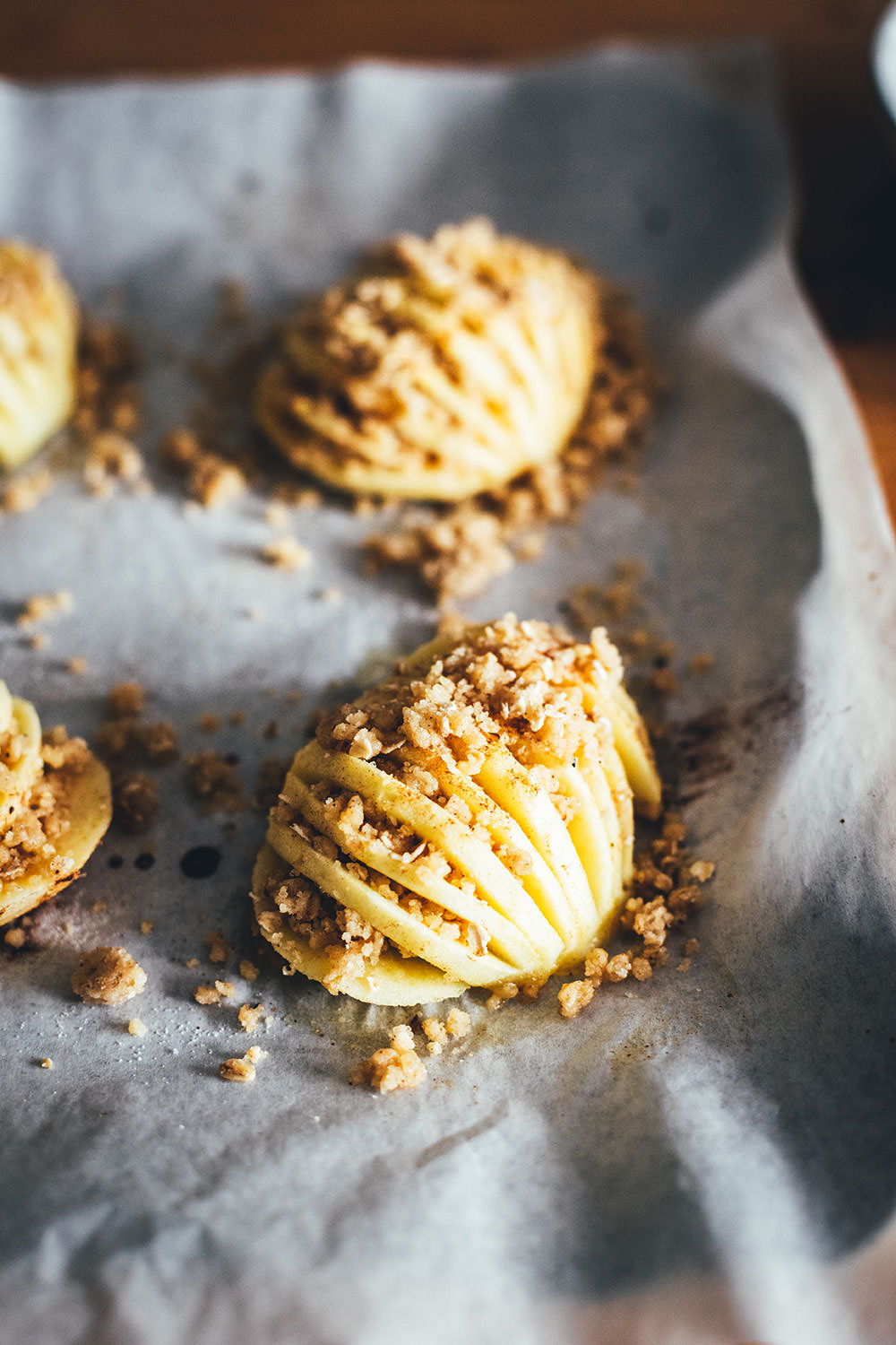 Wunderbare Rezeptidee für gebackene Äpfel mit Streuseln. Süßer Bratapfel trifft auf klassischen Apple Crumble oder Apple Crisp – heraus kommt mein Hasselback Bratapfel. Dafür werden halbierte Äpfel fächerförmig eingeschnitten, im Ofen gebacken und dann mit leckeren Streuseln bestreut. In diesen stecken gehackte Walnüsse und Haferflocken, das macht sie lecker und knusprig! | moeyskitchen.com