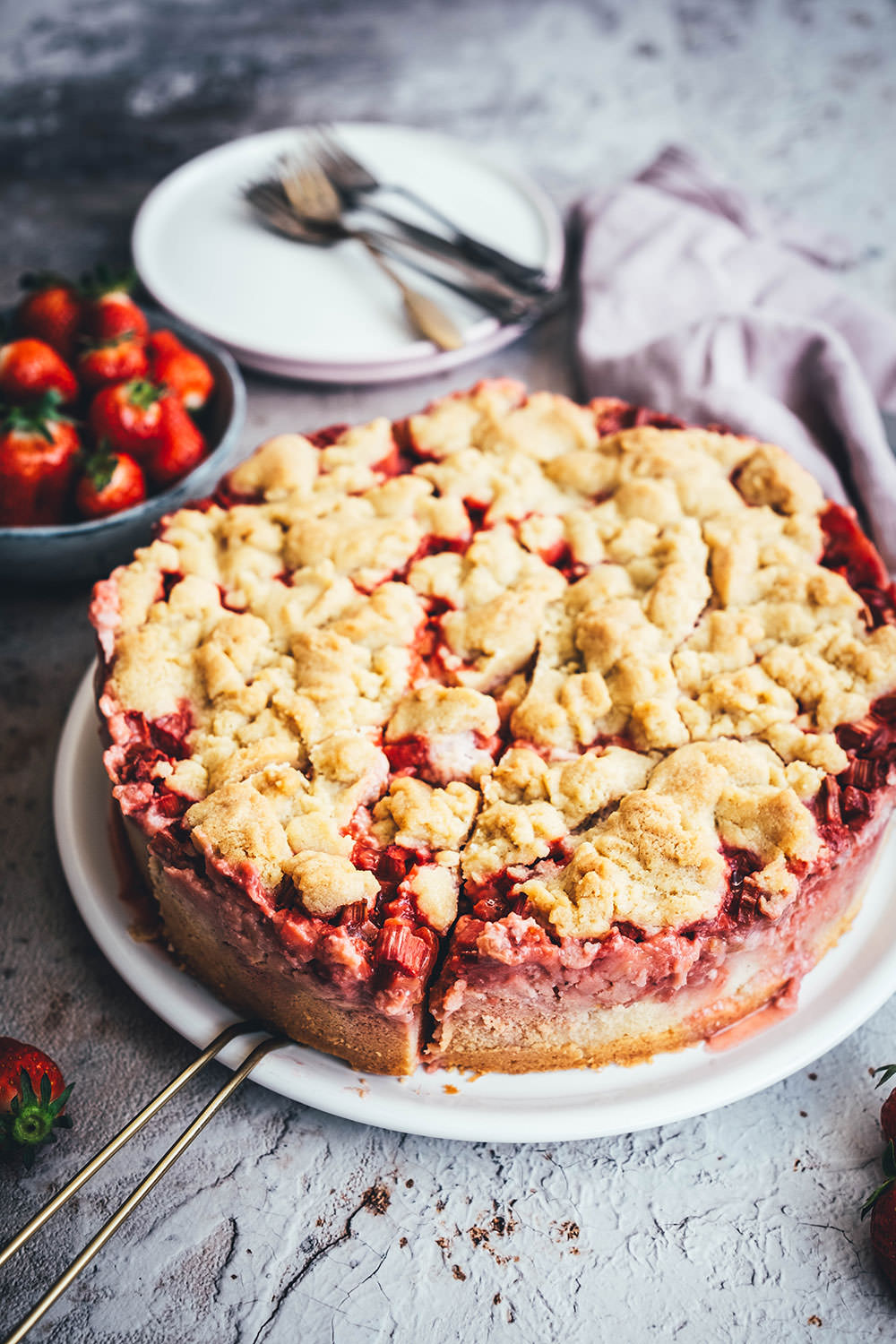 Rezept für einen super saftigen Erdbeer-Rhabarber-Kuchen mit einem selbst gekochten Vanillepudding als Cremeschicht und getoppt mit knusprigen Butter-Streuseln. Der perfekte Streuselkuchen für den Frühling und Sommer. Süße Erdbeeren treffen auf säuerlichen Rhabarber und cremigen Pudding. Dazu gibt es einen einfachen Rührteig-Boden und ein leckeres Streusel-Topping. | moeyskitchen.com