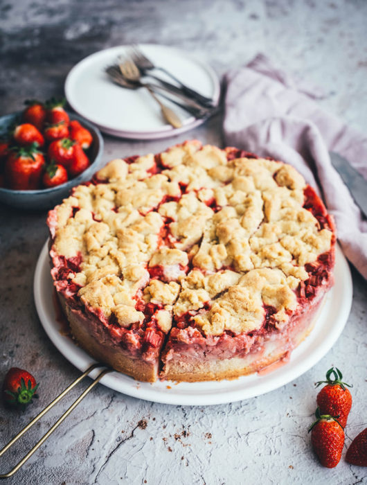 Rezept für einen super saftigen Erdbeer-Rhabarber-Kuchen mit einem selbst gekochten Vanillepudding als Cremeschicht und getoppt mit knusprigen Butter-Streuseln. Der perfekte Streuselkuchen für den Frühling und Sommer. Süße Erdbeeren treffen auf säuerlichen Rhabarber und cremigen Pudding. Dazu gibt es einen einfachen Rührteig-Boden und ein leckeres Streusel-Topping. | moeyskitchen.com