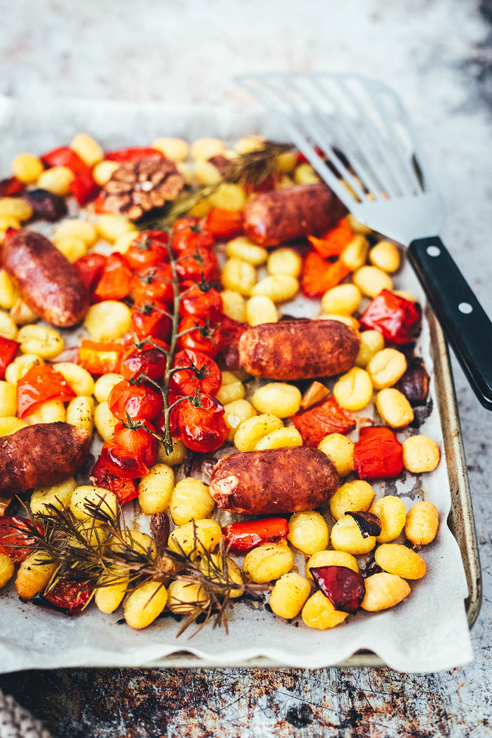 Rezept für One Pan Gnocchi – alles von einem Blech! Blitzschnell zubereitet für die sommerliche Feierabendküche. Gnocchi-Traybake mit Salsiccia, Paprika und Tomaten, serviert mit Knoblauch-Schmand. | moeyskitchen.com