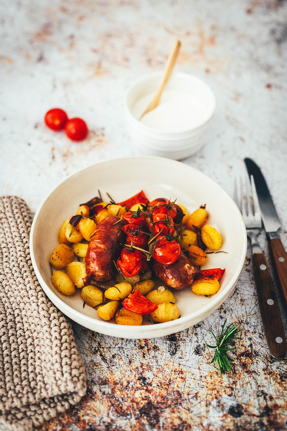 Rezept für One Pan Gnocchi – alles von einem Blech! Blitzschnell zubereitet für die sommerliche Feierabendküche. Gnocchi-Traybake mit Salsiccia, Paprika und Tomaten, serviert mit Knoblauch-Schmand. | moeyskitchen.com