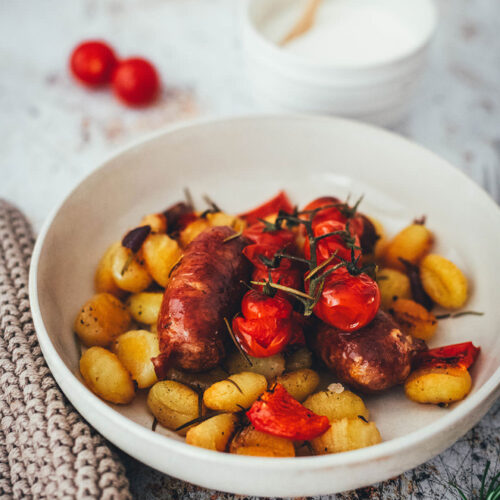 Rezept für One Pan Gnocchi – alles von einem Blech! Blitzschnell zubereitet für die sommerliche Feierabendküche. Gnocchi-Traybake mit Salsiccia, Paprika und Tomaten, serviert mit Knoblauch-Schmand. | moeyskitchen.com