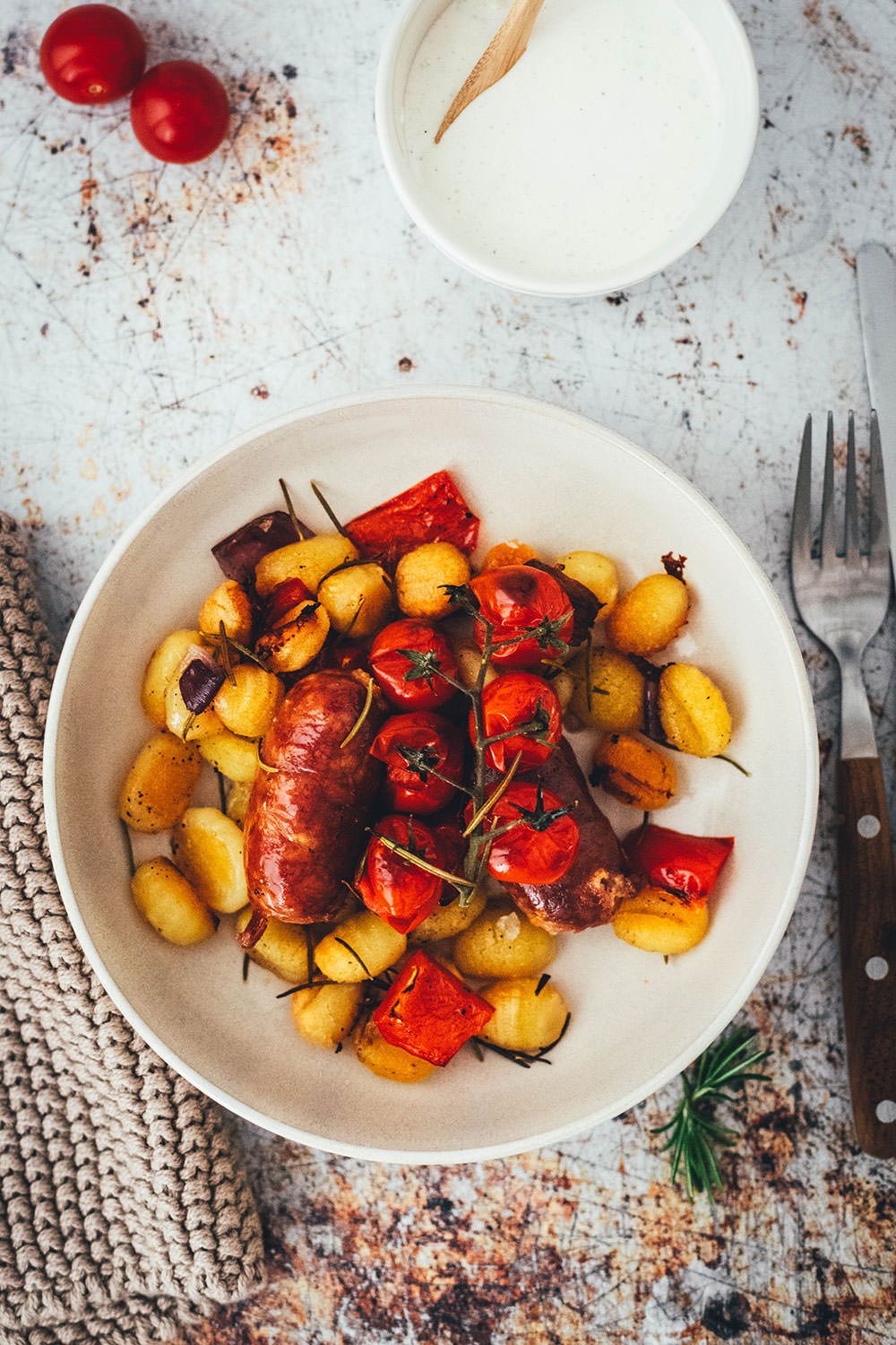 Rezept für One Pan Gnocchi – alles von einem Blech! Blitzschnell zubereitet für die sommerliche Feierabendküche. Gnocchi-Traybake mit Salsiccia, Paprika und Tomaten, serviert mit Knoblauch-Schmand. | moeyskitchen.com