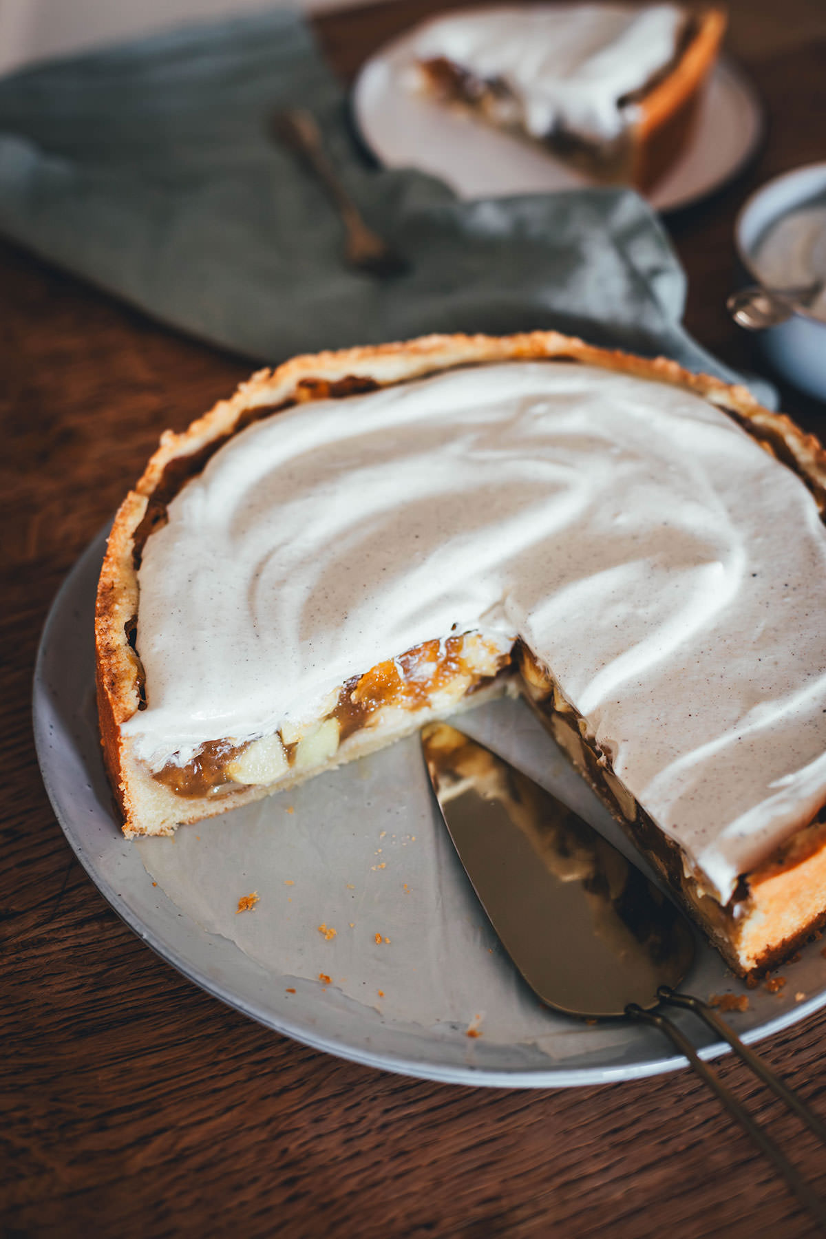 Rezept für Apfelkuchen mit knusprigem Mürbeteigboden und einer Füllung mit Äpfeln. Vanillepuddingpulver wird hier einfach mit Apfelsaft angerührt und mit Apfelstückchen gefüllt. Das ergibt die köstliche Füllung für diesen simplen Apfel-Pudding-Kuchen. Getoppt wird der Kuchen dann mit einer ganz lockeren Schmandcreme mit Vanille. | moeyskitchen.com