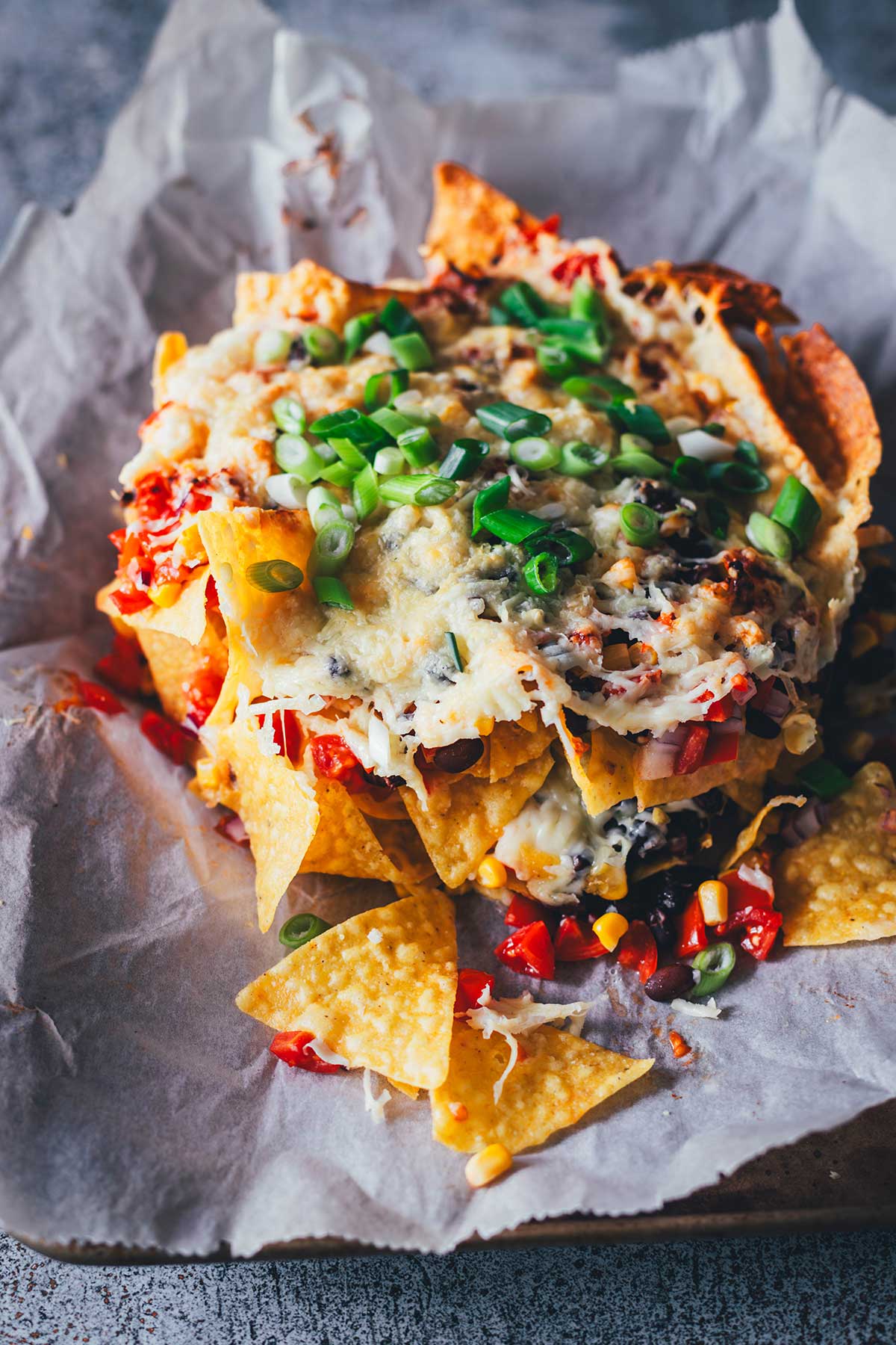 Loaded Nachos aus der Heißluftfritteuse sind eine blitzschnelle und unkomplizierte Idee für mit Käse und Toppings überbackene Tortilla Chips als Snack. Dafür werden alle Zutaten in den Airfryer geschichtet und zusammen gebacken. Anschließend kann man die Nachos mit Guacamole und Sour Cream servieren. | moeyskitchen.com