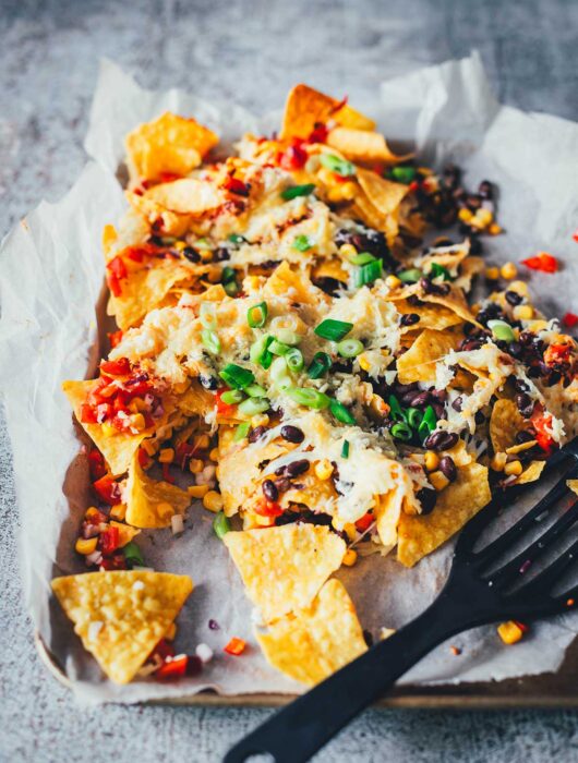 Loaded Nachos aus der Heißluftfritteuse sind eine blitzschnelle und unkomplizierte Idee für mit Käse und Toppings überbackene Tortilla Chips als Snack. Dafür werden alle Zutaten in den Airfryer geschichtet und zusammen gebacken. Anschließend kann man die Nachos mit Guacamole und Sour Cream servieren. | moeyskitchen.com