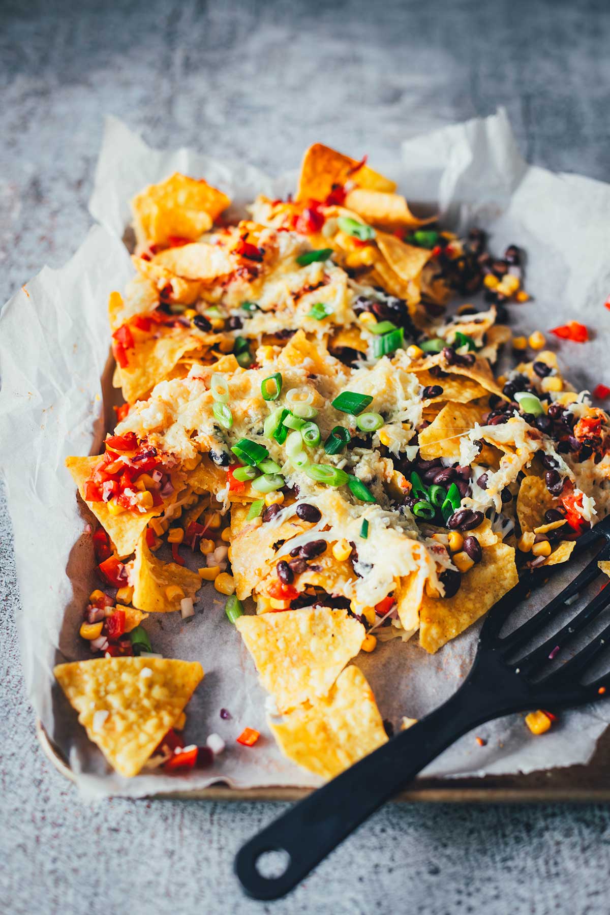 Loaded Nachos aus der Heißluftfritteuse sind eine blitzschnelle und unkomplizierte Idee für mit Käse und Toppings überbackene Tortilla Chips als Snack. Dafür werden alle Zutaten in den Airfryer geschichtet und zusammen gebacken. Anschließend kann man die Nachos mit Guacamole und Sour Cream servieren. | moeyskitchen.com