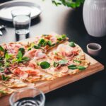 Flammkuchen lässt sich genial einfach selbst herstellen. Mein knuspriger Flammkuchen besteht aus einem simplen Teig ohne Hefe, den ich stattdessen mit Olivenöl und Eigelb etwas verfeinere. Dadurch lässt er sich besonders dünn ausrollen und wird beim Backen so wunderbar knusprig. In diesem Rezept verrate ich euch, wie der perfekte Flammkuchen gelingt und gebe euch direkt Tipps für leckere Kombinationen für den Flammkuchen-Belag! | moeyskitchen.com