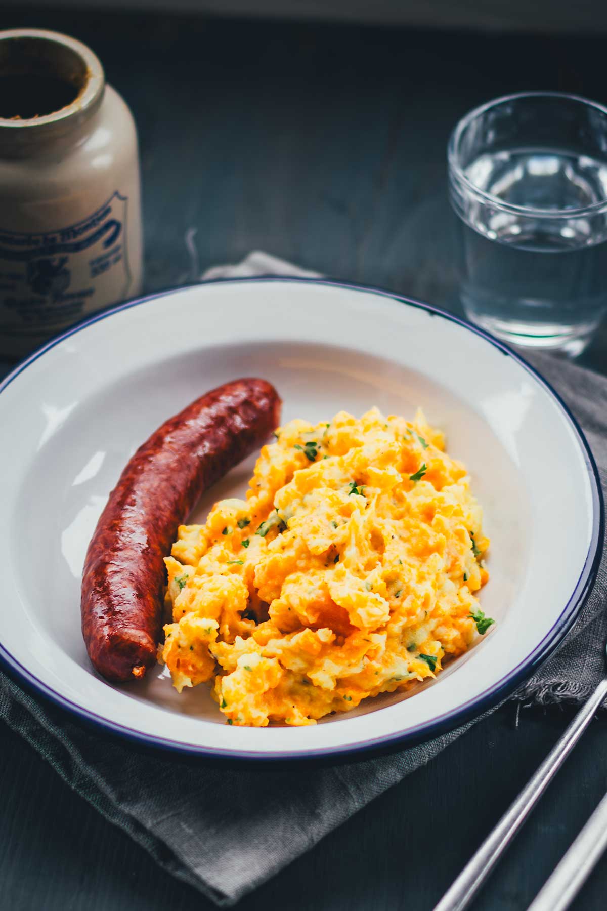 Rezept für einfache und deftige Hausmannskost: Kartoffel-Möhren-Stampf einfach selbst zubereitet. Serviert mit würziger Mettwurst ist das das perfekte Abendessen in der kalten Jahreszeit und genau das richtige für den Herbst. | moeyskitchen.com