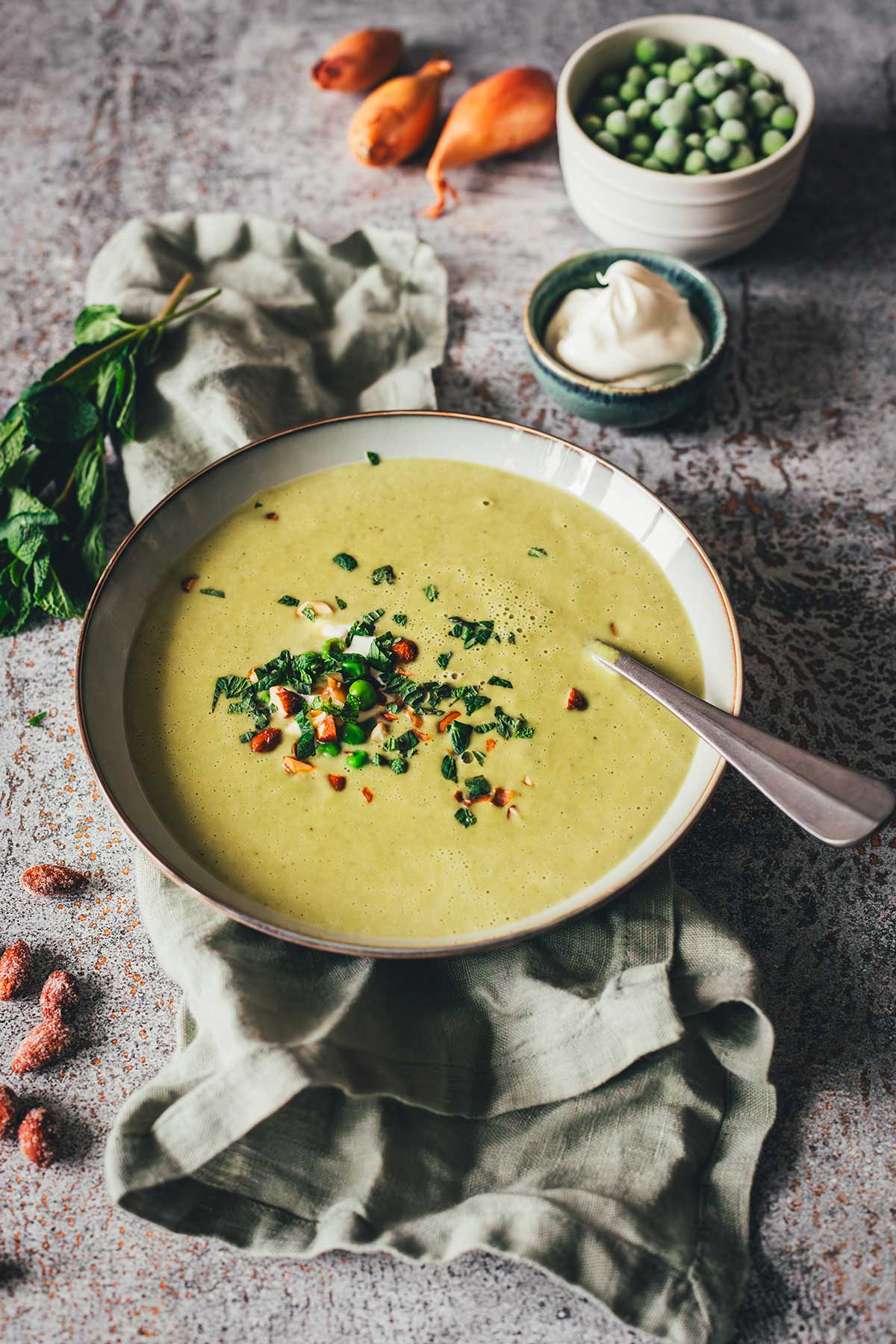 Erbsensuppe mit Minze und Crème fraîche in einer Schale, garniert mit ...