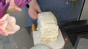 Einzelne Schnittlauchhalme werden als Dekoration rundherum an die Frischkäsecreme gedrückt