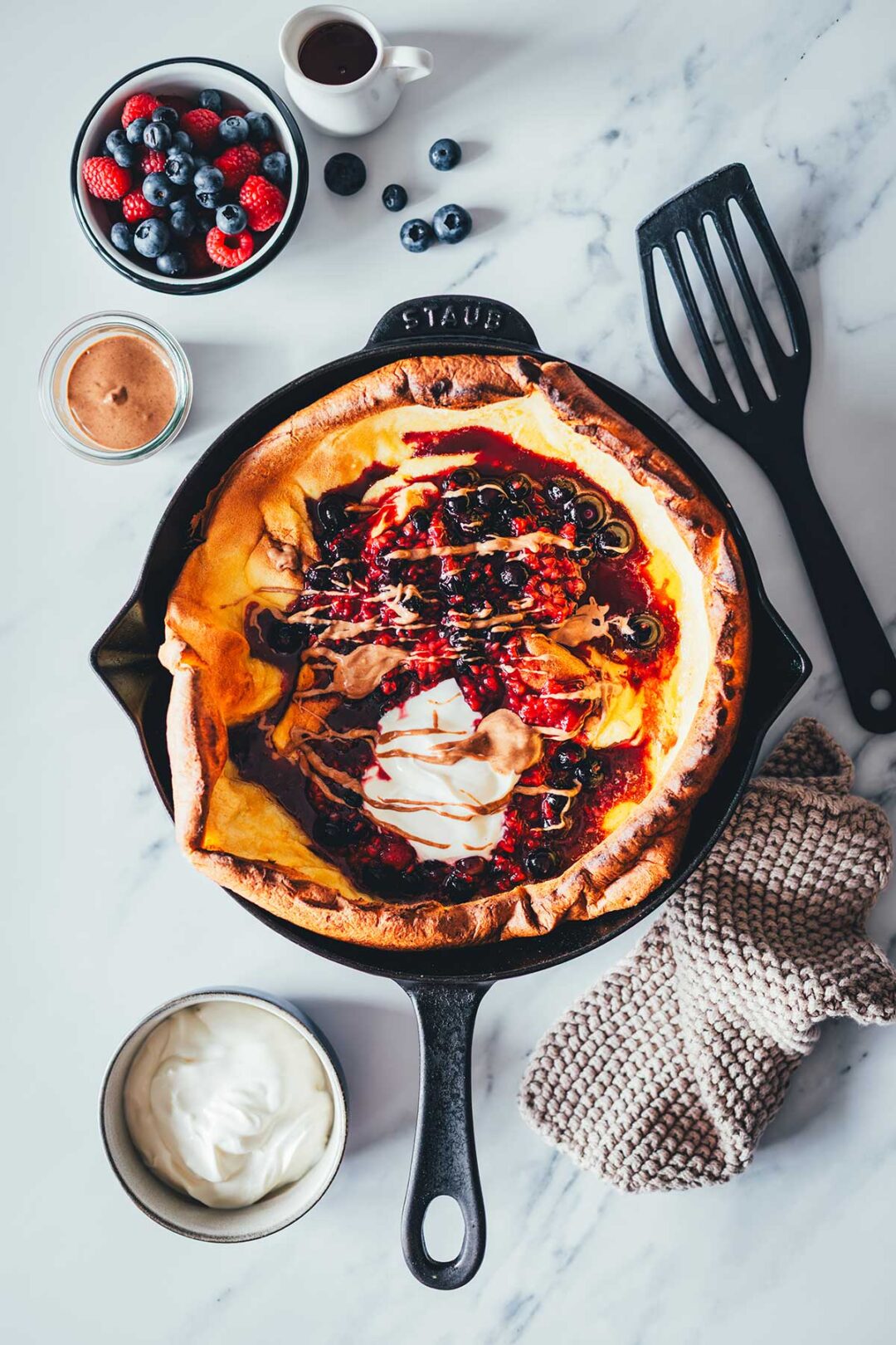 Dutch Baby Rezept für fluffigen Ofenpfannkuchen. Außen knusprig, innen weich, wie ein großer Pancake. Mit Beeren, Ahornsirup und Mandelmus. | moeyskitchen.com